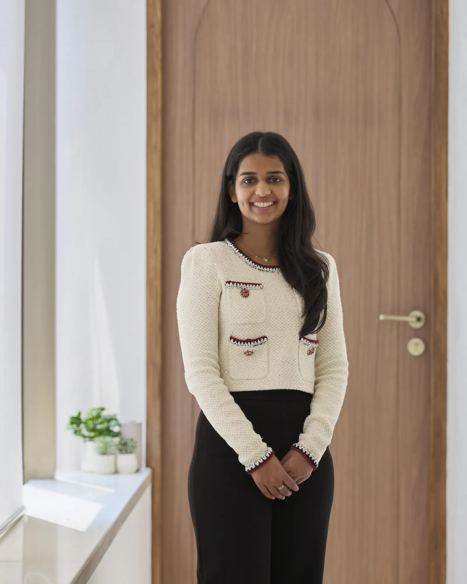 Dr. Ami smiling outside a treatment room at the clinic