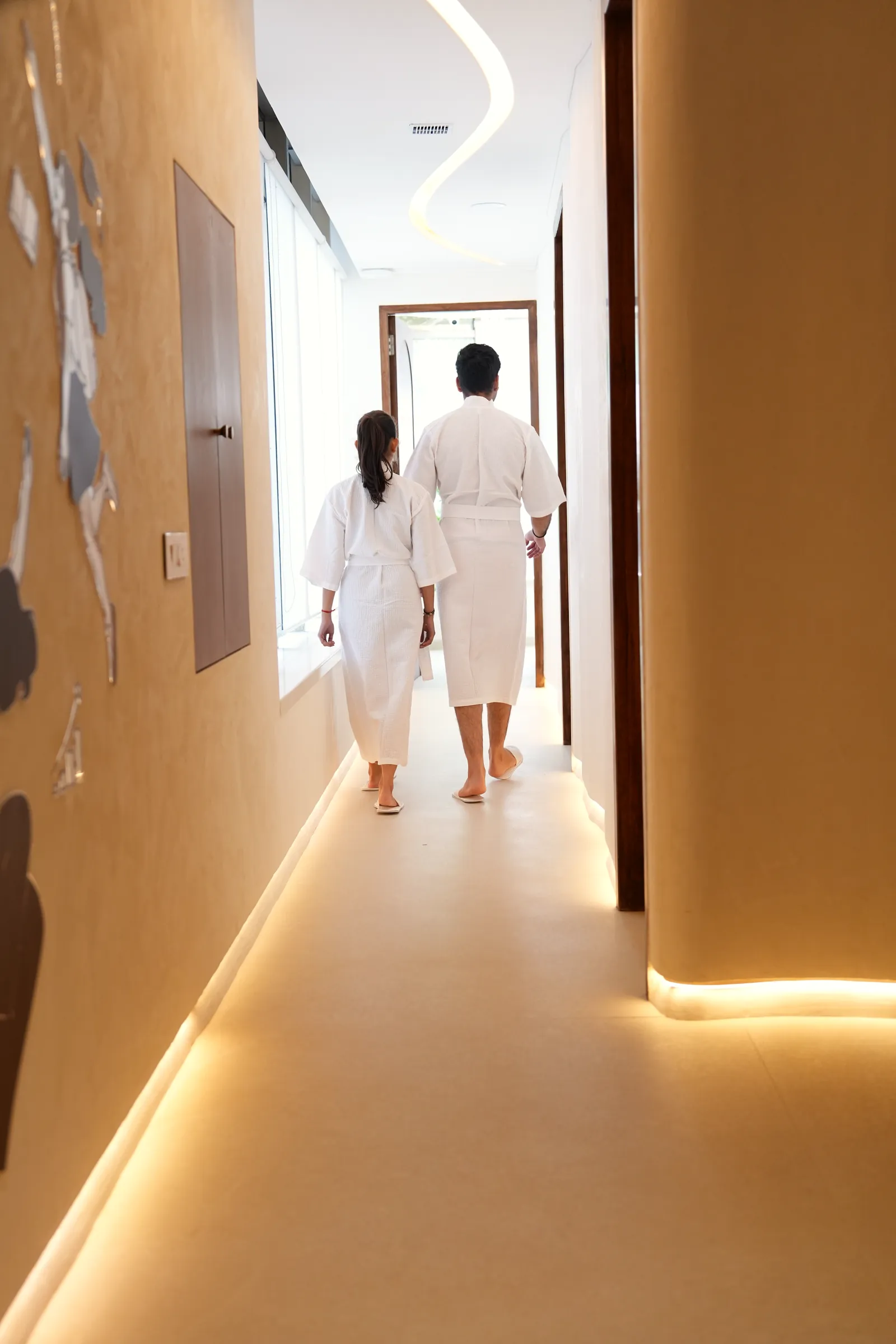 Two guests in robes walking the corridor towards the recovery suite
